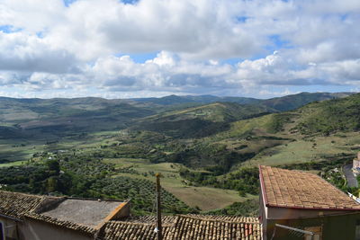 Scenic view of townscape and mountains against sky