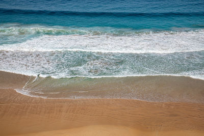 High angle view of waves rushing towards shore