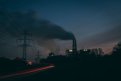 Smoke emitting from factory against sky at night