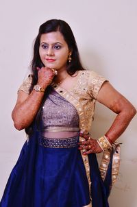 Close-up of beautiful woman in sari against wall