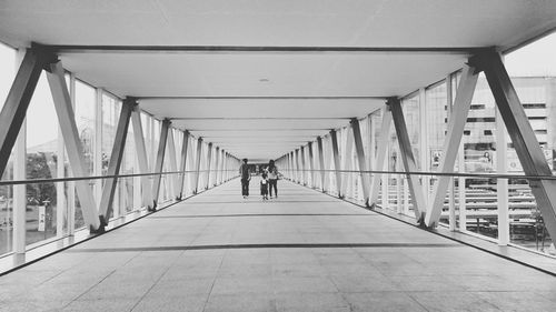 Rear view of people walking on footbridge