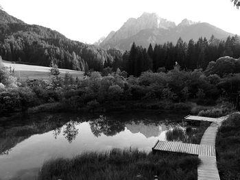 Scenic view of river by mountains against sky