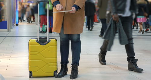 Low section of people walking on tiled floor in city