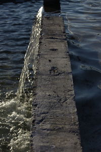 High angle view of wooden posts in sea