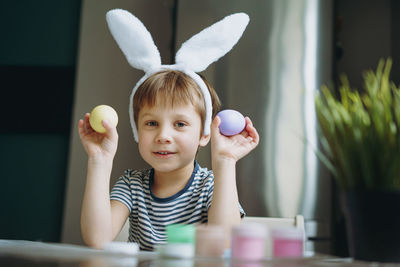 Cute little boy colouring eggs for easter