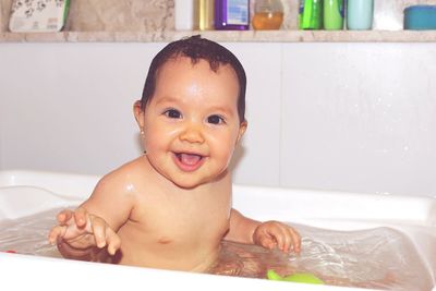 Portrait of cute naked baby girl in bathtub