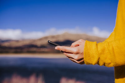 Cropped image of woman using phone outdoors