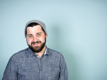 Portrait of smiling bearded man against blue background