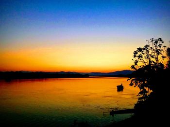 Scenic view of lake against orange sky