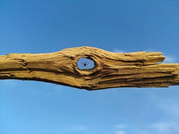 Low angle view of old wood against clear blue sky