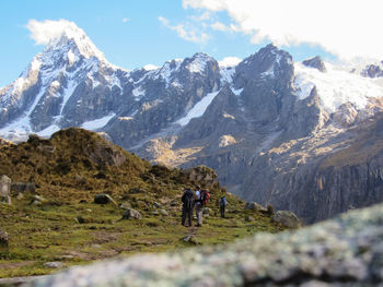 Rear view of man walking on mountain against sky