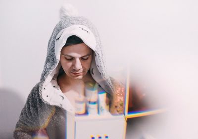 Double exposure image of man wearing hood and cabinet