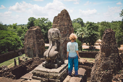 Rear view of mid adult woman standing at ankor wat temple