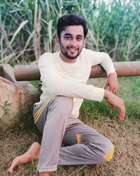 Portrait of young man sitting at farm