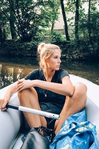 Thoughtful young woman on boat sailing in river