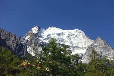 Scenic view of snowcapped mountains against clear blue sky