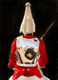 Rear view of army soldier against black background