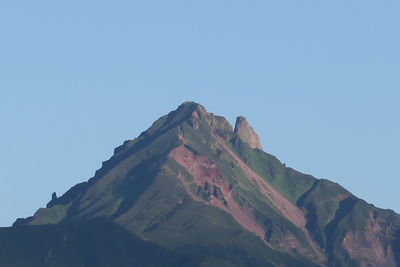 Low angle view of mountain against clear blue sky