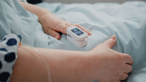 Cropped hand of doctor holding thermometer