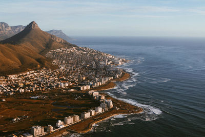 Scenic view of sea by mountains against sky