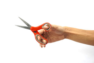 Close-up of hand holding eyeglasses against white background