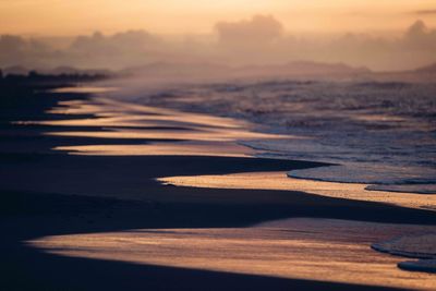 Scenic view of beach against sky during sunset