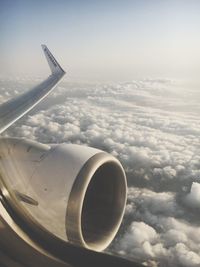 Airplane flying over cloudscape against sky