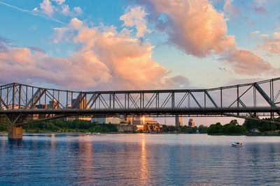 Bridge over river against sky during sunset