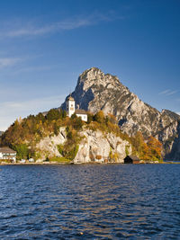 Scenic view of sea by buildings against sky