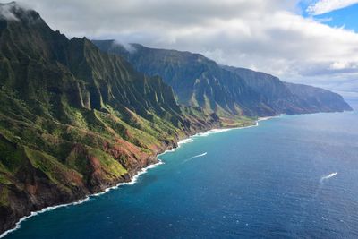 Scenic view of sea and mountains against sky