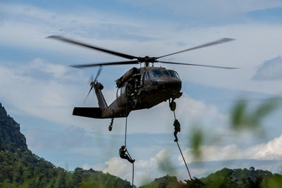 Low angle view of helicopter flying against sky