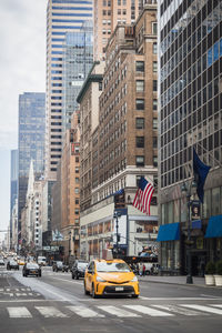 Vehicles on road amidst buildings in new york city