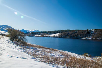 Scenic view of snowcapped mountains against clear blue sky