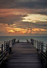 Pier over sea against sky during sunset