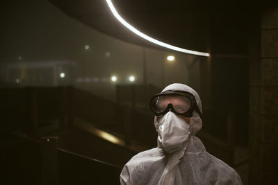 Portrait of man wearing sunglasses standing against illuminated ceiling