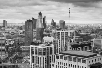 Aerial view of buildings in city against sky