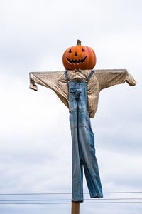 Low angle view of scarecrow against sky