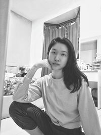 Portrait of young woman sitting at home