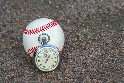 Close-up of ball and stopwatch on the ground