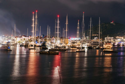 Boats moored in harbor at night