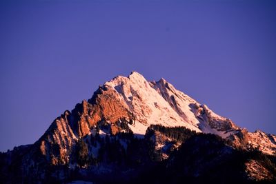 Low angle view of rocky mountains against clear sky