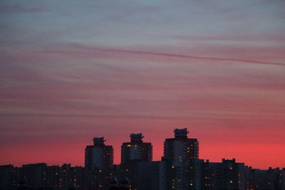 Illuminated cityscape against sky during sunset