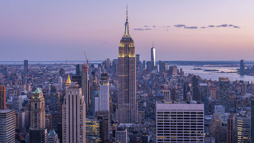 Modern buildings in city against sky during sunset