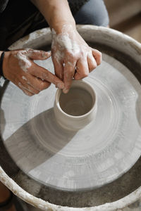 Hands close-up at pottery workshop learning to make clay bowl. people doing handmade dishes. lesson