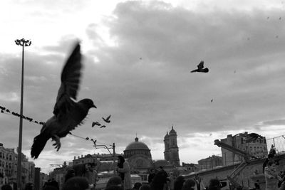 Low angle view of people against cloudy sky