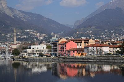 Buildings by lake against sky