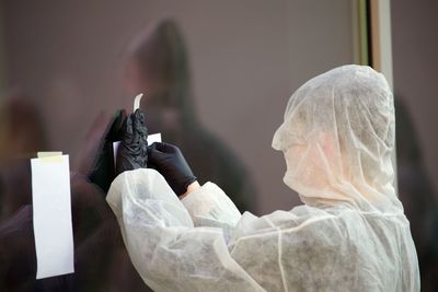 Man in protective workwear holding adhesive note