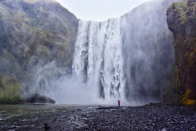 Low angle view of waterfall against clear sky