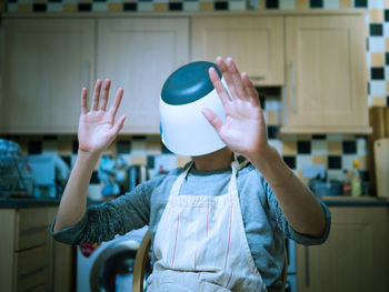 Man with container on head in kitchen