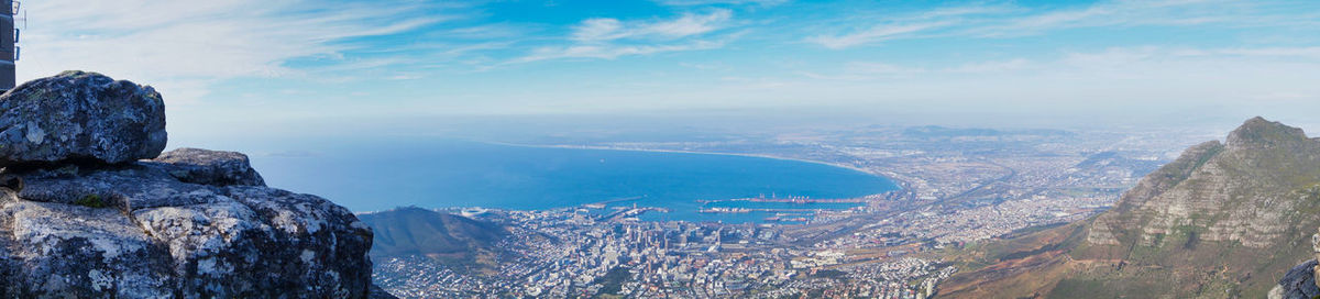 Aerial view of city by sea against sky